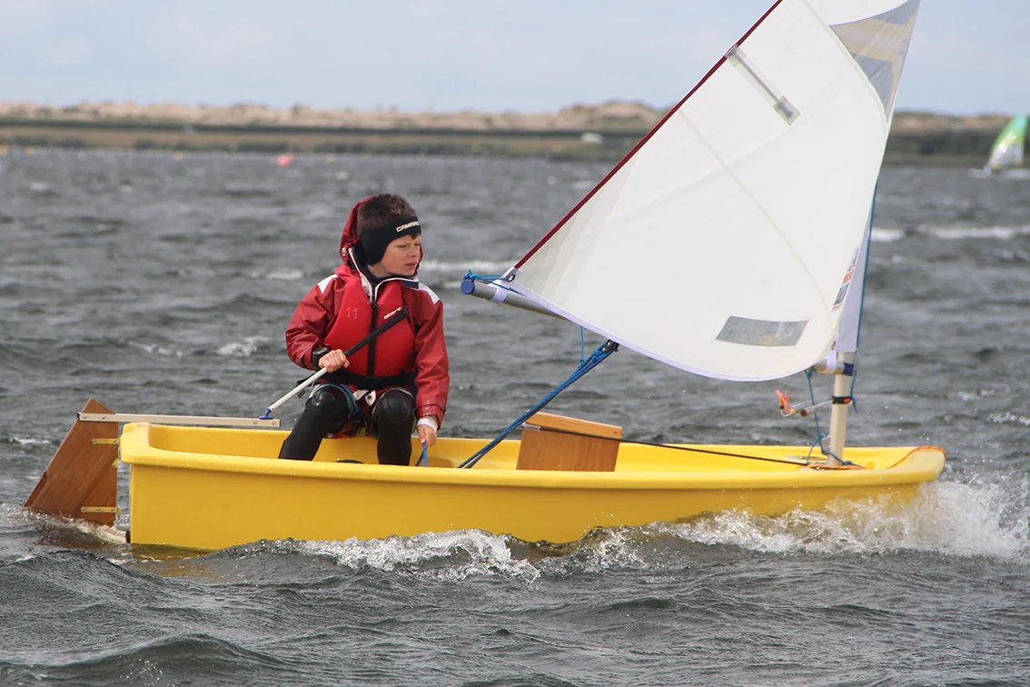 Optimist WorldWideSailor de escuela navegando