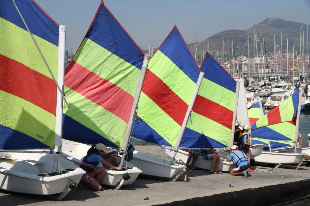 Barcos de escuela de vela con velas de colores